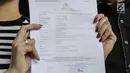 Artis peran Tyas Mirasih menunjukkan surat laporan pencemaran nama baik usai melapor ke Polda Metro Jaya, Jakarta, Rabu (21/3). Tyas melaporkan pihak yang menuduhnya telah menculik anak. (Liputan6.com/Faizal Fanani)