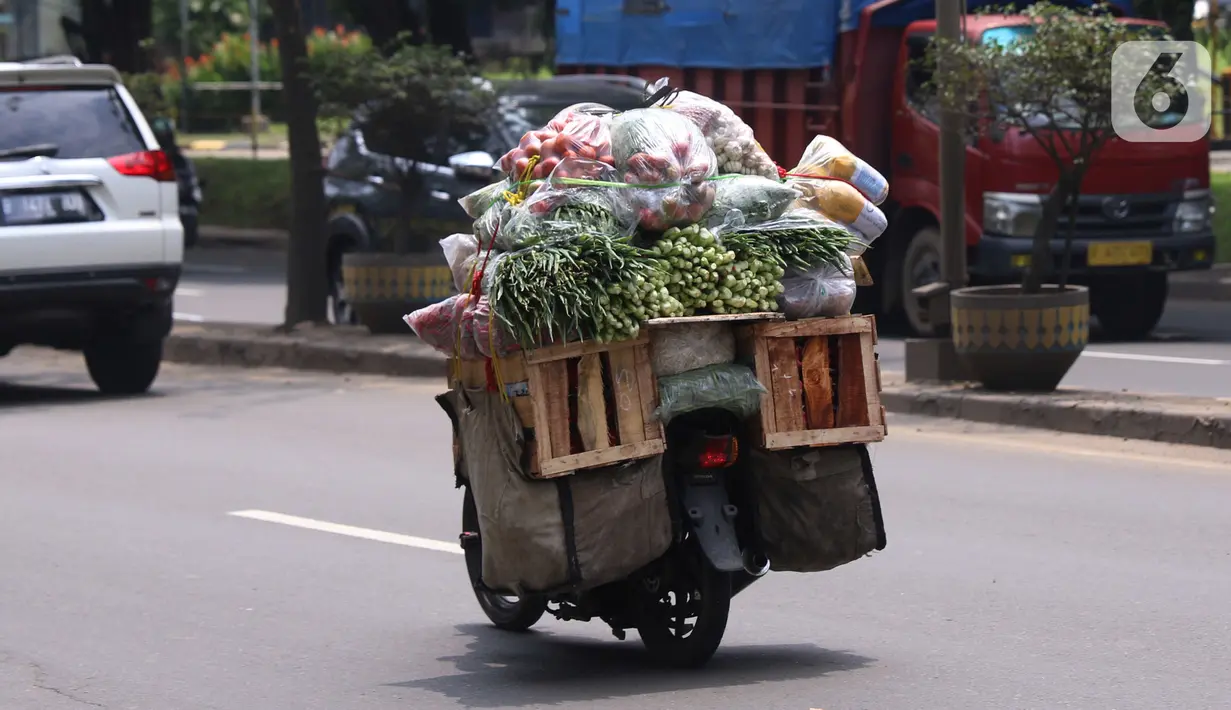 Warga membawa bahan makanan dengan sepeda motor saat melintas di kawasan Tangerang, Banten, Rabu (16/2/2022).Bank Indonesia (BI) memperkirakan terjadi penurunan harga komoditas atau deflasi pada Februari 2022. (Liputan6.com/Angga Yuniar)