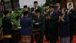 Prabowo Subianto dan Gibran Rakabuming Raka menerima berkas berita acara pelantikan dari Ketua MPR RI Ahmad Muzani. (Liputan6.com/Herman Zakharia)