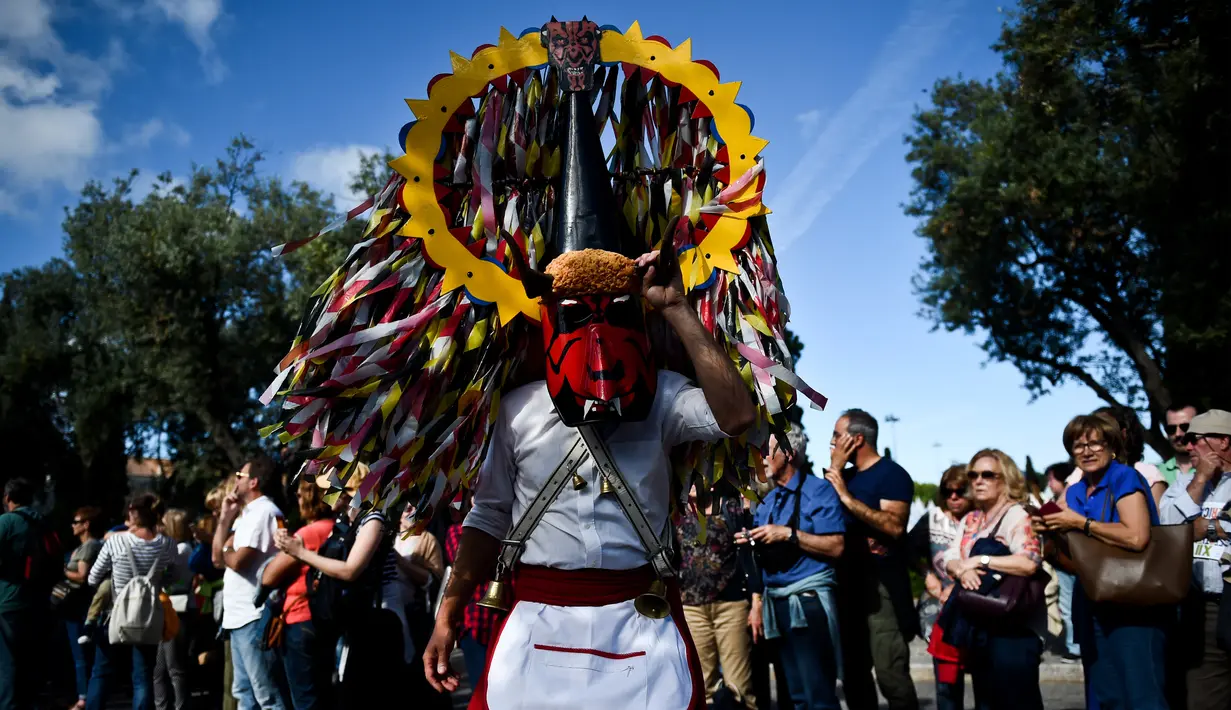 Seorang anggota Caretos de Lagoa mengenakan kostum lengkap dengan atributnya saat mengikuti International Festival of the Iberian Mask ke-12 di Belem, Lisbon, Portugal (5/6). (AFP Photo/Patricia De Melo Moreira)