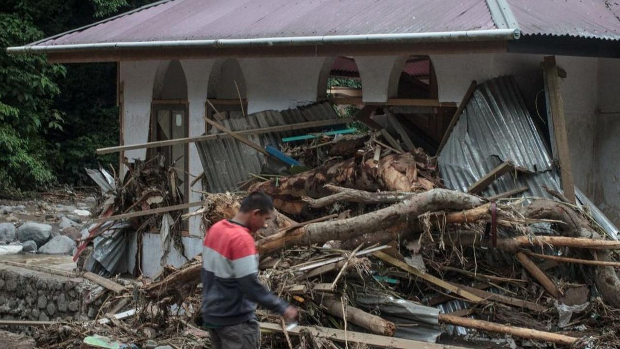 Dari pantauan di lokasi, banjir lahar dingin membawa material batu-batu hingga batang pohon.<br><br>Bencana ini juga mengakibatkan setengah badan jalan raya longsor. Foto: REZAN SOLEH / AFP