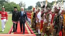 Presiden Jokowi bersama Raja Swedia Carl XVI Gustaf saat melaksanakan upacara jajar pasukan di Istana Kepresidenan Bogor, Senin (22/5). Kehadiran Raja Swedia disambut langsung Jokowi yang mengenakan pakaian adat Betawi. (Liputan6.com/Angga Yuniar)