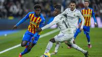 Pemain Valencia Yunus Musah, kiri, melangkah ke samping pemain Real Madrid Eduardo Camavinga selama pertandingan sepak bola La Liga Spanyol antara Real Madrid dan Valencia di stadion Santiago Bernabeu di Madrid, Kamis, 2 Februari 2023. (AP Photo/Bernat Armangue)