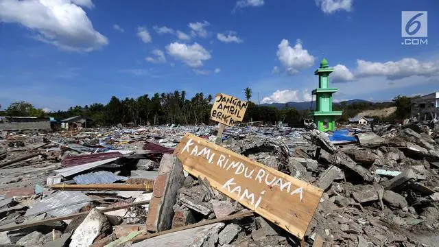 Sebuah papan dengan pesan Kami Rindu Rumah Kami dipasang pasca gempa bumi dan tsunami di pinggir Jalan Trans Sulawesi, Palu, Sulawesi Tengah, Kamis (4/10). (Liputan6.com/Fery Pradolo)