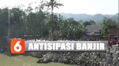 Warga Pacitan membuat penahan tanggul sementara untuk mengansisipasi banjir.