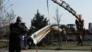 Alat berat dikerahkan untuk mengangkat puing helikopter yang hancur usai menabrak menara stasiun televisi, Turki, Jumat (10/3). Lima orang yang berada di dalamnya tewas seketika. (AP Photo)