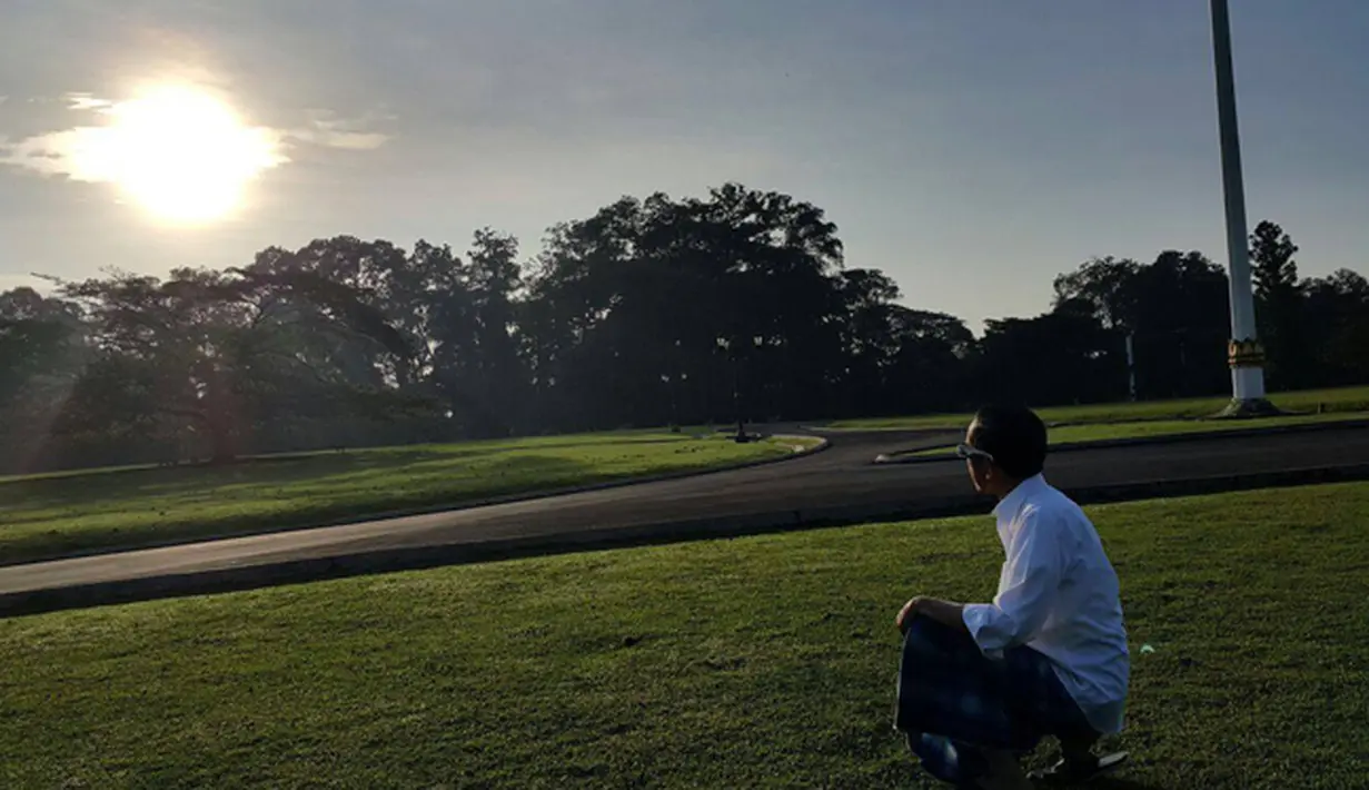 Presiden Jokowi menyaksikan keindahan fenomena Gerhana Matahari di halaman Istana Bogor, Rabu (9/3). Dengan peenampilan yang santai memakai sarung Jokowi tampak menikmati keindahan fenomena alam yang luar biasa tersebut. (facebook.com/Jokowi)