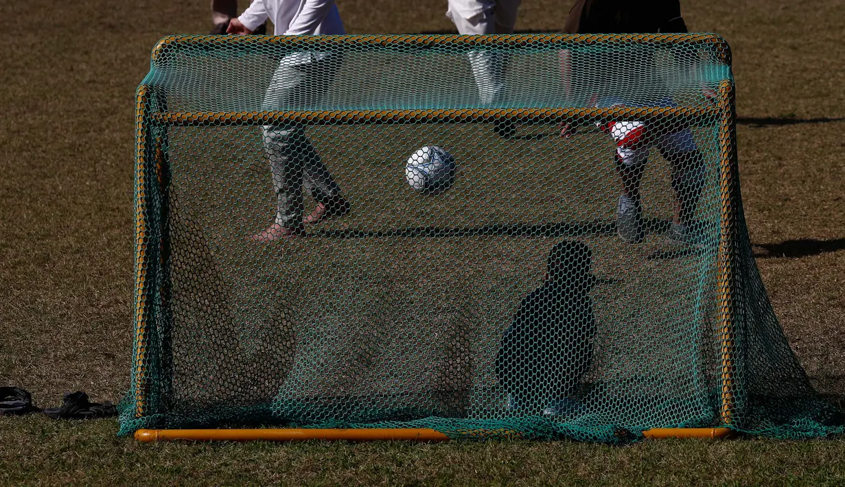 Pengungsi Afghanistan bermain sepak bola di taman bermain Institut Pengembangan Sumber Daya Manusia Nasional di Jincheon, Korea Selatan (13/10/2021). Para pengungsi muncul di hadapan publik pada hari Rabu, untuk pertama kalinya sejak mereka tiba pada akhir Agustus. (AFP/Pool/Jeon Heon-kyun)