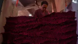 Gambar pada 11 Desember 2019 menunjukkan pekerja menumpuk dupa yang baru diproduksi di Pabrik Dupa Fujian Xingquan, Provinsi Fujian, China. Mendekati liburan Tahun Baru Imlek, ini adalah waktu yang penting tahun bagi penduduk desa ini yang memasok banyak dupa dunia. (HECTOR RETAMAL/AFP)