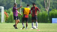 Pelatih Arema FC, Fernando Valente, memberikan instruksi kepada Flabio Soares dan Bayu Aji dalam latihan di Lapangan ARG, Kabupaten Malang, Selasa (9/1/2024). (Bola.com/Iwan Setiawan)