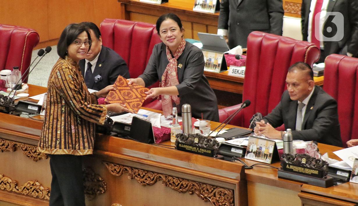 Menteri Keuangan (Menkeu) Sri Mulyani Indrawati menyerahkan draf pandangan pemerintah kepada Ketua DPR RI Puan Maharani saat rapat Paripurna DPR RI Ke-13 Masa Persidangan II Tahun Sidang 2022-2023 di Kompleks Parlemen, Senayan, Jakarta, Kamis (15/12/2022). DPR menyetujui Rancangan Undang-undang Pengembangan dan Penguatan Sektor Keuangan menjadi UU PPSK. (Liputan6.com/Angga Yuniar)