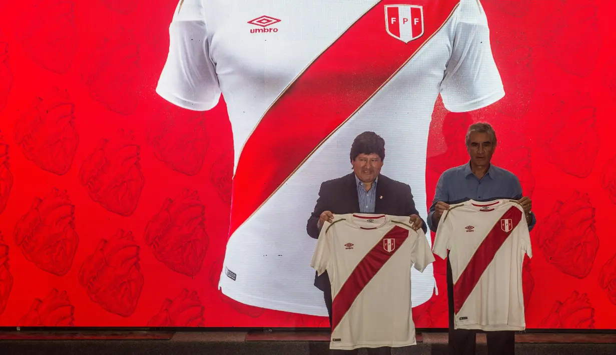 Presiden Federasi Sepakbola Peru Edwin Oviedo (kiri) memegang kaos resmi timnas Peru untuk Piala Dunia 2018 di Rusia di Lima (18/12). Piala Dunia 2018 di Rusia akan berlangsung pada 14 Juni - 15 Juli tahun depan. (AFP Photo/Ernesto Benavides)