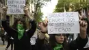 Dua orang demonstran menunjukan poster saat menggelar aksi di Buenos Aires, Argentina (29/9). Dalam aksi ini mereka meminta dekriminalisasi aborsi, atau meminta perbuatan aborsi bukan lagi menjadi pelanggaran hukum. (AFP Photo/Juan Mabromata)