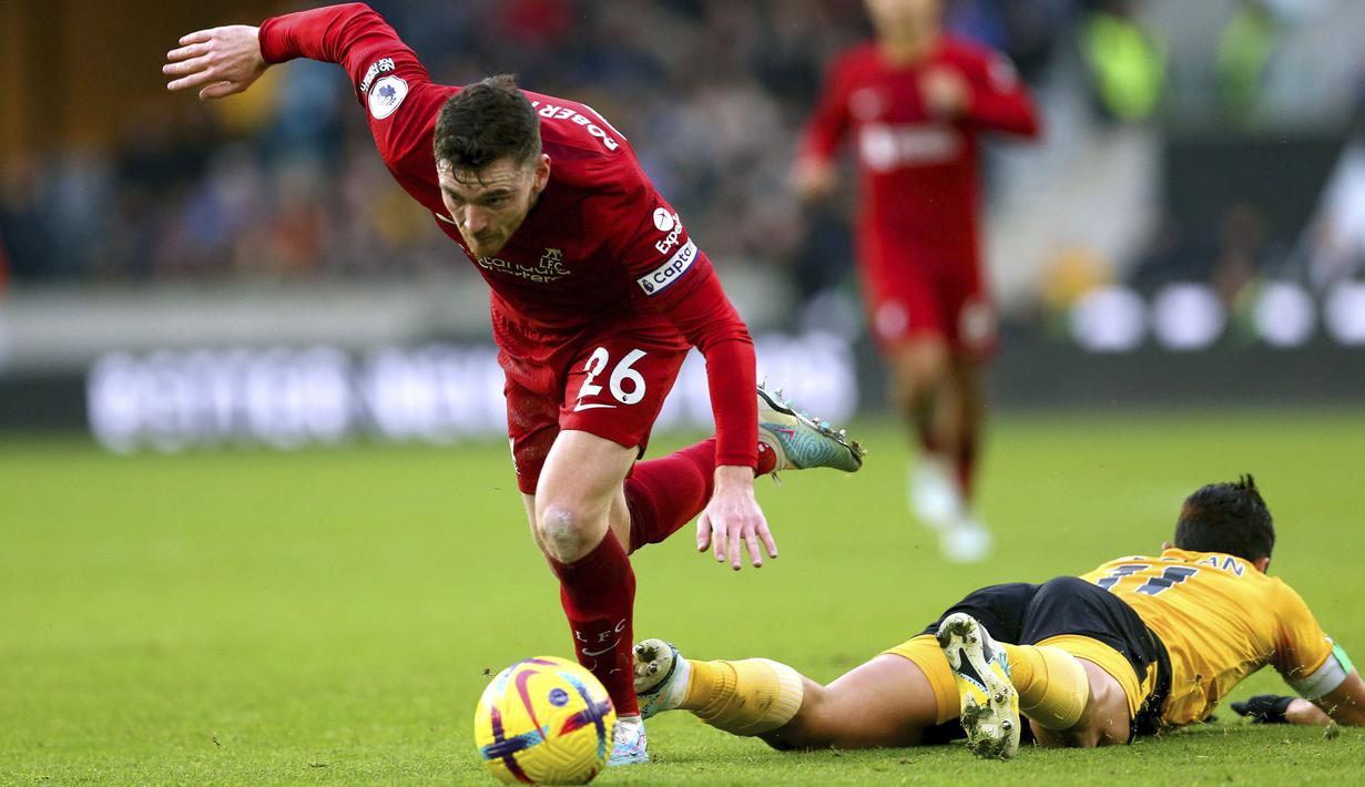 Pemain Liverpool, Andrew Robertson (kiri) berusaha melewati pemain Wolverhampton, Hwang Hee-chan pada laga pekan ke-22 Liga Inggris 2022/2023 di Molineux Stadium, Sabtu (04/02/2023). Liverpool kalah dengan skor 0-3 dari Wolves. (AP via PA/Tim Goode)