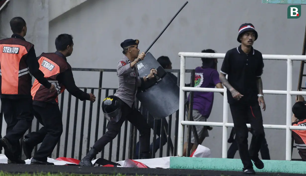 Polisi mengusir suporter Persita Tangerang yang masuk ke lapangan saat melawan Kalteng Putra pada laga Liga 2 di Stadion Pakansari, Jawa Barat, Selasa (4/12). Kalteng menang 2-0 atas Persita. (Bola.com/M. Iqbal Ichsan)
