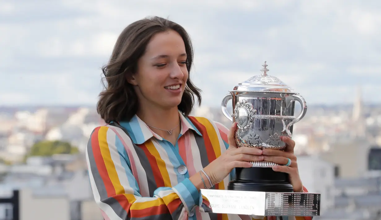 Petenis Polandia Iga Swiatek berpose dengan trofi juara Prancis Terbuka 2020 saat sesi foto di rooftop Galeries Lafayette, Paris, Prancis, Minggu (11/10/2020). Petenis berusia 19 tahun ini mencatatkan diri sebagai sosok Polandia pertama yang memenangkan Grand Slam. (AP Photo/Christophe Ena)