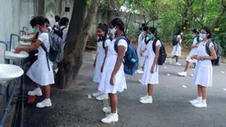 Para siswa yang mengenakan masker berbaris untuk mencuci tangan di sebuah sekolah di Kolombo, Sri Lanka, Senin (6/7/2020). Mulai 6 Juli 2020, siswa kelas 5, 11, dan 13 di Sri Lanka kembali melanjutkan kegiatan belajar. (Xinhua/Ajith Perera)