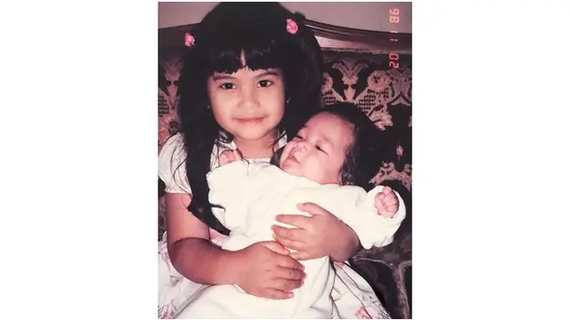 Potret masa kecil Annisa Pohan saat menggendong adik laki-lakinya.