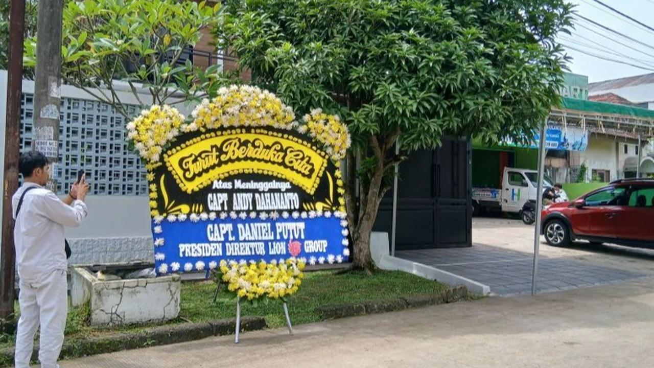 Jurnalis sedang memotret kediaman mendiang capt andy pilot pesawat atr 42-500 jatuh di maros