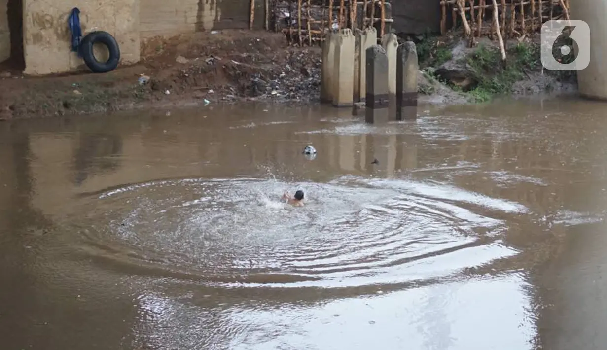 Anak-anak berenang di Sungai Ciliwung, Rawajati, Jakarta, Selasa (17/12/2019). Meski debit air Sungai Ciliwung naik akibat hujan mengguyur Jakarta sejak siang hingga sore, anak-anak tersebut tetap nekat berenang tanpa memedulikan keselamatan. (Liputan6.com/Immanuel Antonius)