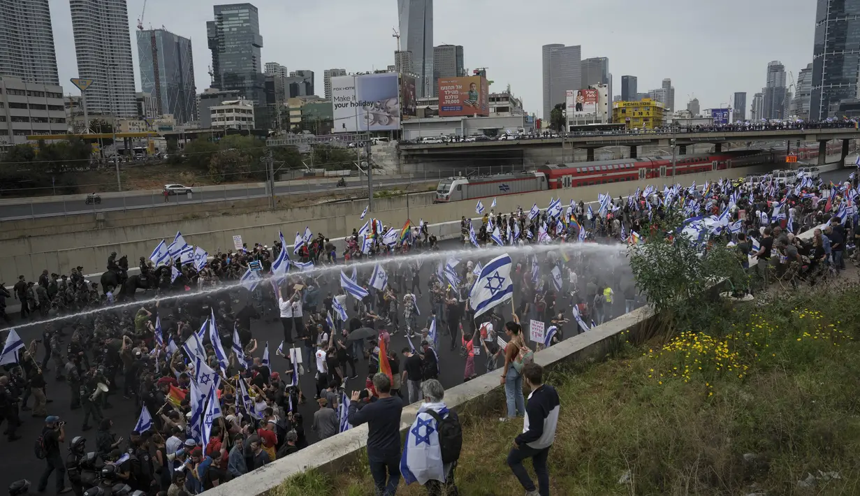 Para pengunjuk rasa memblokir jalan raya utama di tepi laut Tel Aviv dan polisi menggunakan meriam air untuk membubarkan para demonstran di kota itu dan Haifa di utara. (AP Photo/Oded Balilty)