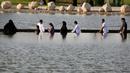 Pengunjung melintasi danau di Quranic Park, Dubai,Uni Emirat Arab, 6 April 2019. Quranic Park memiliki berbagai macam tanaman yang disebutkan dalam Alquran. (REUTERS/Satish Kumar)
