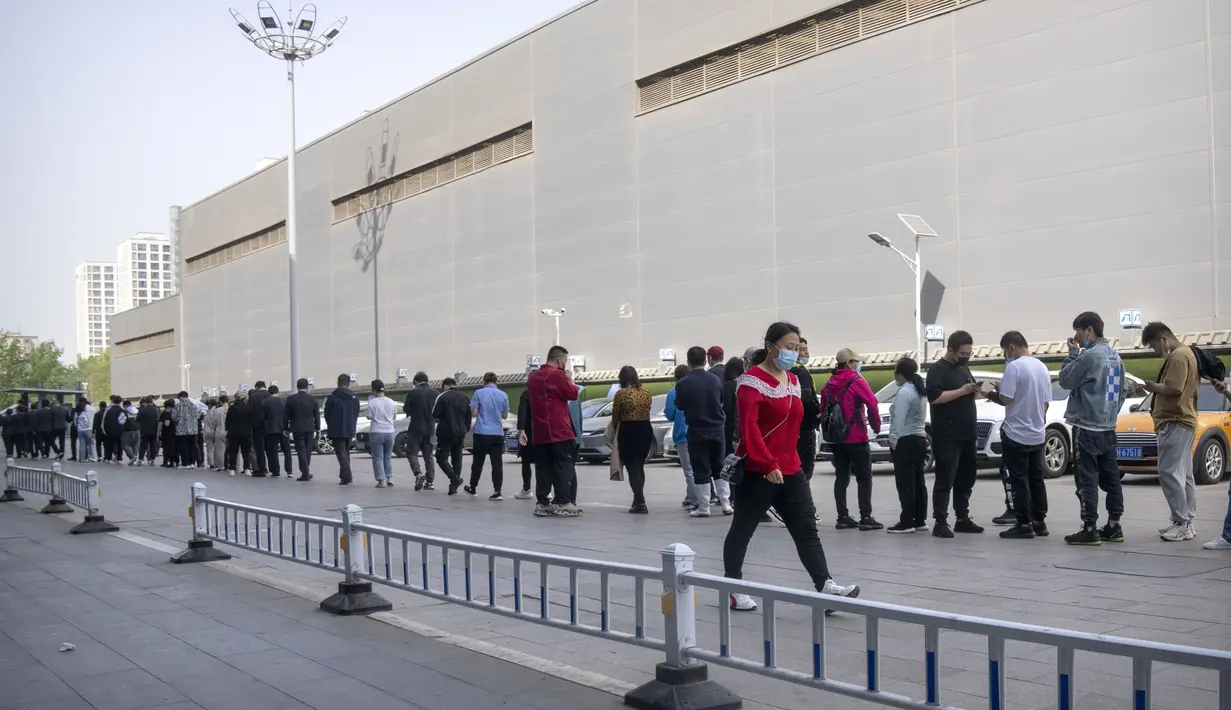 <p>Orang-orang mengantre untuk tes COVID-19 di fasilitas pengujian virus corona di Beijing, China, Sabtu (23/4/2022). Beijing dalam keadaan waspada setelah 10 siswa sekolah menengah dinyatakan positif COVID-19 pada hari Jumat, yang menurut pejabat kota sebagai putaran awal pengujian. (AP Photo/Mark Schiefelbein)</p>