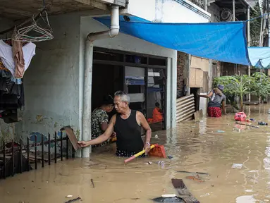 Warga dengan alat seadanya membersihkan rumah yang terendam banjir di kawasan Rawajati, Kalibata, Jakarta, Senin (10/10/2022). Tingginya curah hujan di kawasan Bogor mengakibatkan ratusan rumah di enam RT Kelurahan Rawajati terendam banjir dengan ketinggian mencapai dua meter. (Liputan6.com/Faizal Fanani)