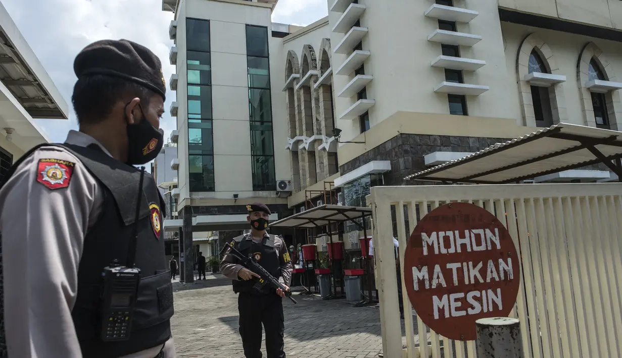 Anggota kepolisian berjaga saat proses penyisiran sebuah gereja di Surabaya menjelang Paskah setelah bom bunuh diri di katedral Makassar, Rabu (31/3/2021). Kegiatan tersebut merupakan upaya peningkatan pengamanan tempat ibadah, khususnya gereja di kota pahlawan. (Juni Kriswanto/AFP)