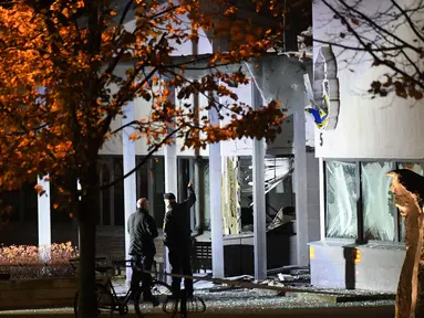 Petugas mengecek kantor polisi setelah ledakan dahsyat di pintu masuk utama di Helsingborg, Swedia (18/10). Ledakan terjadi tengah malam waktu setempat dan juga menghancurkan jendela sebuah bangunan. (AFP Photo/TT News Agency /Johan Nilsson/Sweden Out)