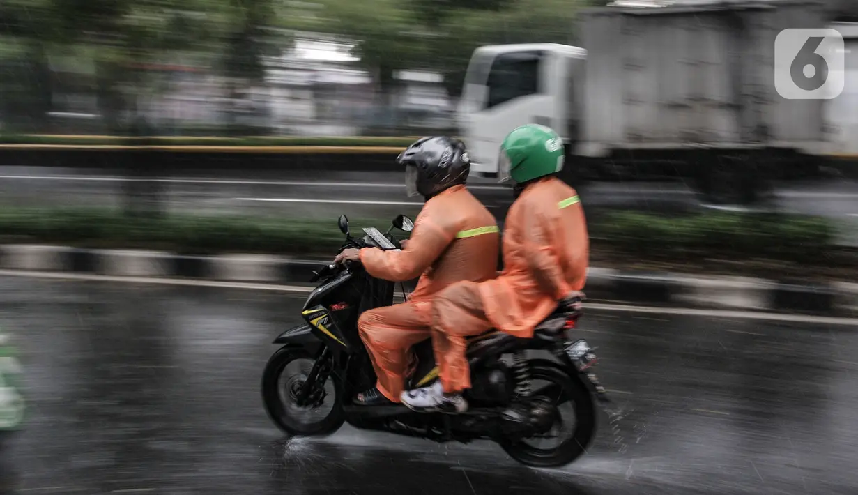 Pengendara menerobos hujan di Jalan Pramuka, Jakarta, Kamis (18/2/2021). Badan Meteorologi Klimatologi dan Geofisika (BMKG) mengimbau pengguna jalan agar berhati-hati saat berkendara karena hujan disertai angin kencang diprediksi terus berlanjut hingga akhir Februari. (merdeka.com/Iqbal S Nugroho)