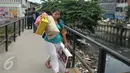Seorang warga sambil membawa barang miliknya mulai meninggalkan kawasan Kalijodo, Jakarta, Kamis (18/2). Lokalisasi itu mulai ditinggalkan penghuni sejak berkembangnya wacana penggusuran kawasan Kalijodo. (Liputan6.com/Gempur M Surya)