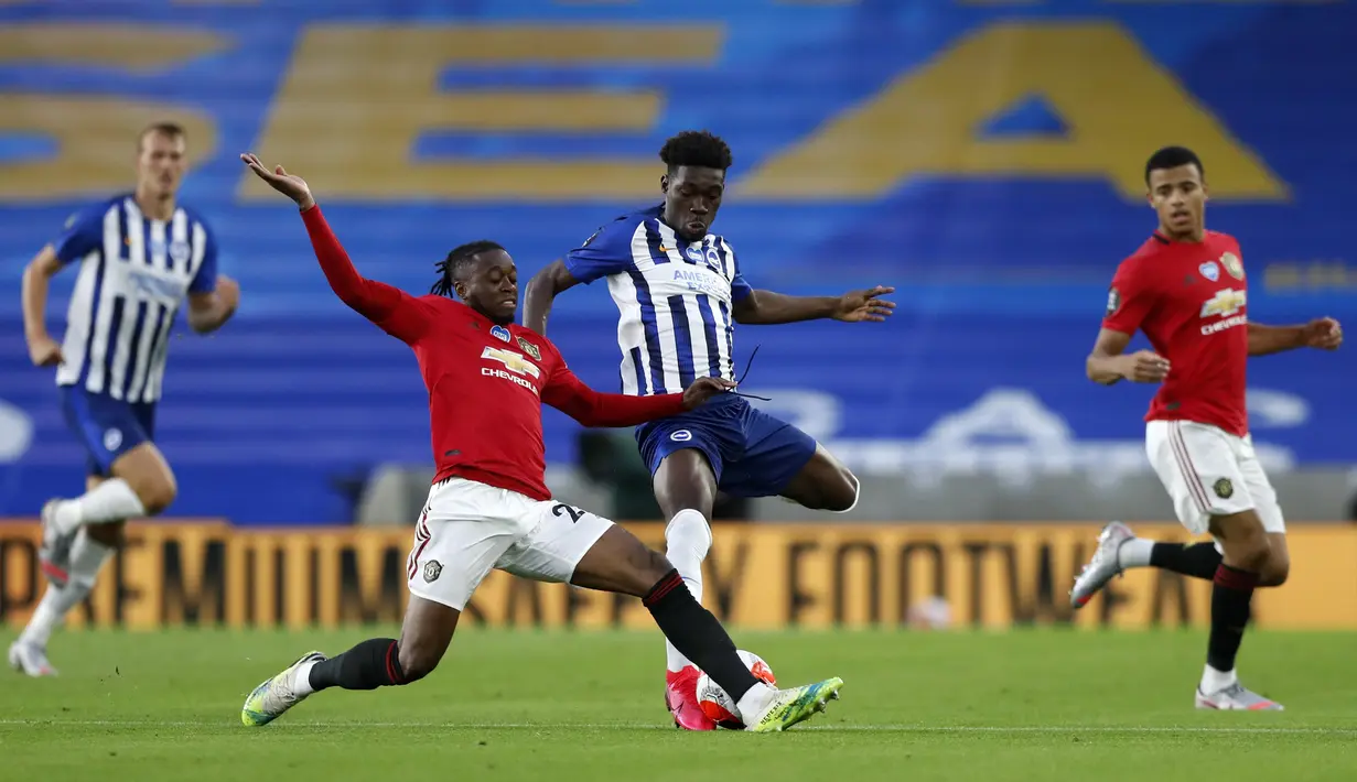 Pemain Manchester United Aaron Wan-Bissaka (kiri) dan pemain Brighton Yves Bissouma berebut bola pada pertandingan Premier League di Stadion AMEX, Brighton, Inggris, Selasa (30/6/2020). Manchester United menang 3-0 dengan dua gol dicetak Bruno Fernandes. (AP Photo/Alastair Grant, Pool)