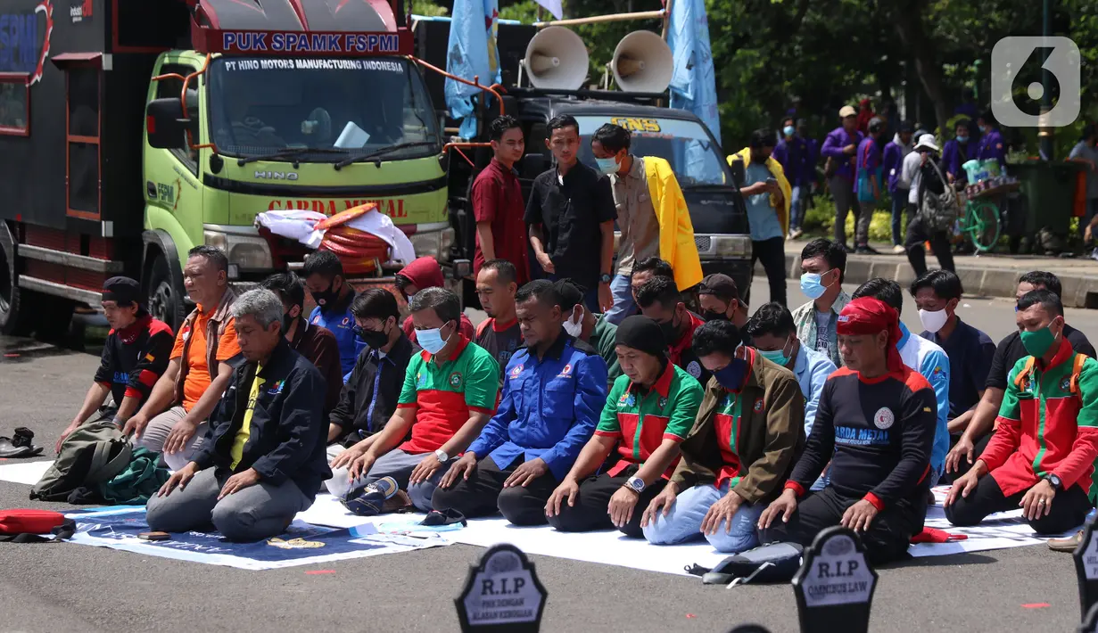 Sejumlah buruh menunaikan salat zuhur di sela aksi Hari Buruh Internasional atau May Day di Jakarta, Sabtu (1/5/2021). Sejumlah massa yang tergabung dalam serikat pekerja menggelar unjuk rasa di Hari Buruh ini. (Liputan6.com/Angga Yuniar)