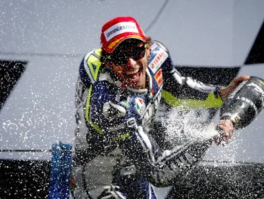Pembalap tim Movistar Yamaha MotoGP Valentino Rossi merayakan di podium setelah memenangkan MotoGP Belanda di Assen pada 29 Juni 2013. Valentino Rossi resmi memutuskan untuk pensiun dari MotoGP. Pria Italia itu tidak akan membalap lagi di musim 2021. (AFP/Catrinus Van Der Veen/ANP)