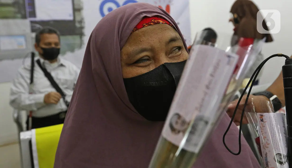 Seorang penumpang menerima bunga dari petugas PT KAI Daop 1 Jakarta yang mengenakan kebaya di Stasiun Gambir, Rabu (21/4/2021). Petugas perempuan itu mengenakan kebaya dan membagikan bunga kepada penumpang guna memeriahkan Hari Kartini yang jatuh pada hari ini. (Liputan6.com/Herman Zakharia)
