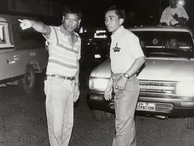 Gambar yang diambil pada awal 1990-an memperlihatkan Rodrigo Duterte (kiri) yang masih menjabat sebagai Wali Kota Davao, membantu seorang polisi untuk mengatur kemacetan lalu lintas di jalanan pusat kota Davao, Filipina selatan. (REUTERS/Renato Lumawag)