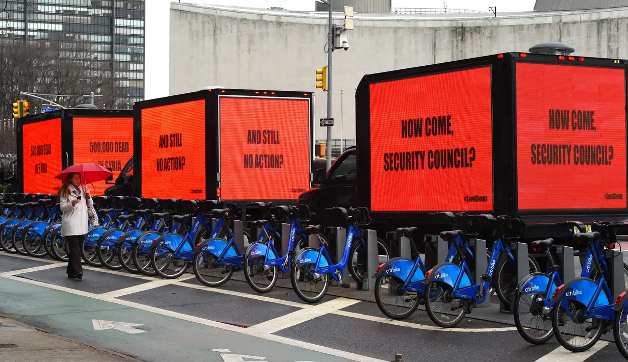 Sejumlah mobil box membawa billboard yang bertema kepedulian untuk Suriah mengelilingi gedung PBB di New York (22/2). Kampanye kemanusian untuk Suriah ini dilakukan jelang pemilihan Dewan Keamanan PBB di New York. (AFP Photo/Timothy A. Clary)