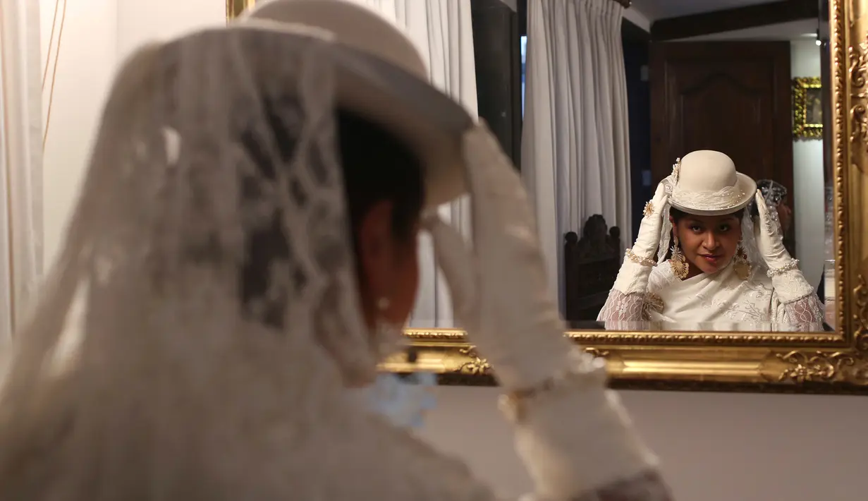 Model bercermin sebelum mengikuti pameran di Museum Desain Pakaian Ana Palza di La Paz, Bolivia (20/5). Pameran ini menampilkan sejumlah rancangan gaun pengantin tradisional Bolivia. (AP Photo/Juan Karita)