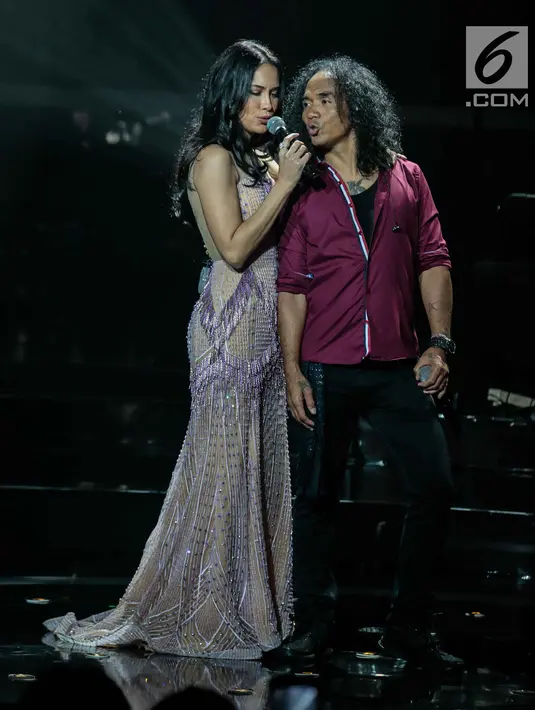 Vokalis grup band Slank Kaka tampil bersama Sophia Latjuba dalam konser Slank In Love di Jakarta, Selasa (27/2). Sophia pun mengenakan dress panjang yang berkilau, begitu juga Kaka yang memainkan gitar dalam lagu tersebut. (Liputan6.com/Faizal Fanani)