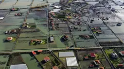 Air hujan membanjiri Desa Obot, sekitar 100 kilometer (60 mil) barat laut Tirana, Albania, Senin (11/1/2021). Pihak berwenang telah mengevakuasi banyak warga menyusul banjir yang merendam ribuan hektare (acre) kawasan di Albania. (AP Photo/Hektor Pustina)