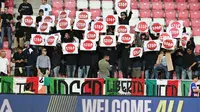 Suporter Italia memegang spanduk bertuliskan 'Berhenti' sebelum dimulainya pertandingan kualifikasi Piala Dunia 2026 Grup I zona Eropa antara Israel dan Italia pada 9 September 2025 di Debrecen, Hungaria. (Attila KISBENEDEK/AFP)