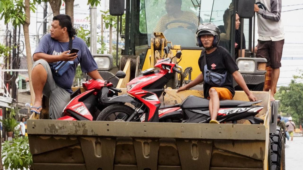 Sejumlah pengendara sepeda motor dievakuasi menggunakan buldoser saat banjir merendam salah satu kawasan di Kota Semarang, Jawa Tengah, Jumat (15/3/2024). Banjir yang terjadi sejak Kamis (14/3) dini hari masih merendam sejumlah titik di Ibu Kota Jawa Teng