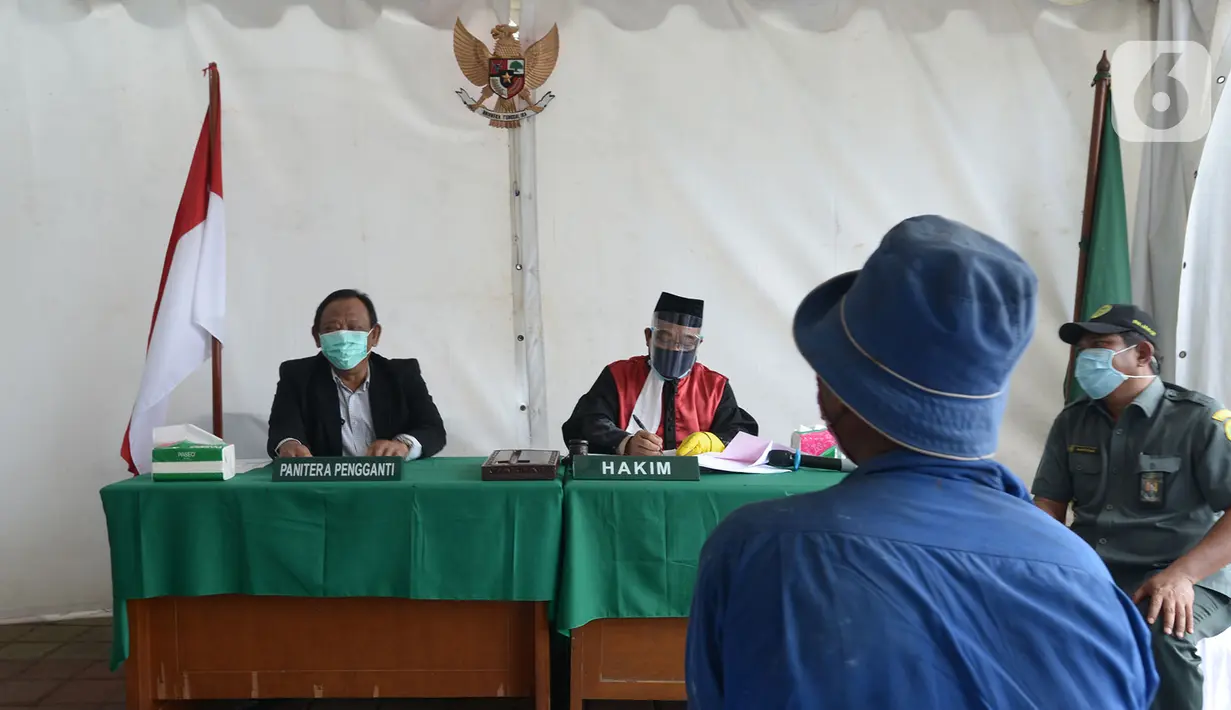 Pelanggar mengikuti sidang di tempat saat Operasi Yustisi di Kawasan Danau Sunter, Jakarta, Rabu (16/9/2020). Warga yang melanggar protokol Covid-19 langsung disidang tindak pidana ringan (tipiring) di tempat dengan membayar denda Rp 55.000 maupun sanksi sosial. (merdeka.com/Imam Buhori)