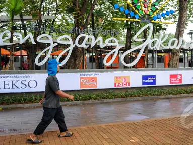 Kios 'Lenggang Jakarta' kini mulai ramai didatangi pengunjung di kawasan Monas, Jakarta, Jumat (17/4/2015). Seorang warga tampak melintas  di depan Kios 'Lenggang Jakarta'. (Liputan6.com/Faizal Fanani)
