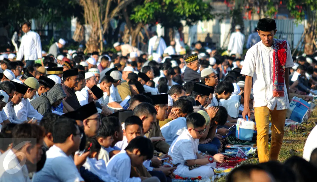 Ribuan umat muslim menunaikan ibadah salat Idul Fitri 1 Syawal 1436 H di Masjid Agung Al Azhar Jakarta, Jumat (17/7/2015). Tampak, salah satu warga mencari tempat untuk melaksanakan salat Id di halaman Masjid Agung Al Azhar. (Liputan6.com/Yoppy Renato)