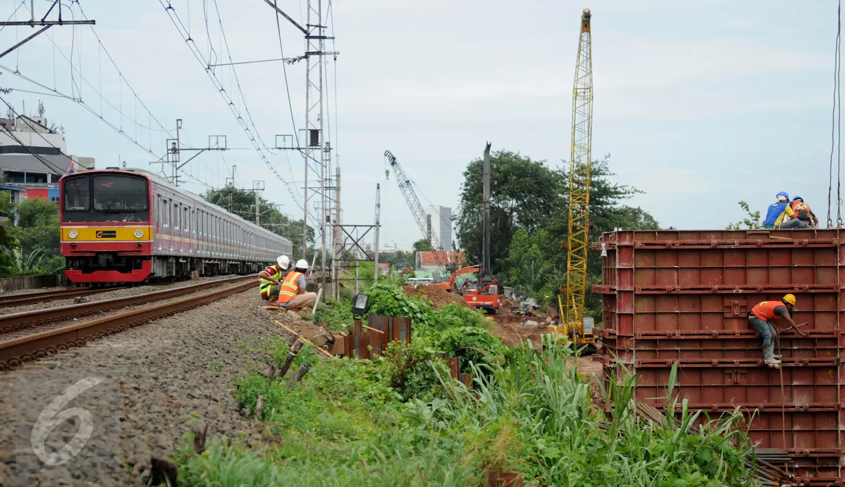  Kereta milintas di dekat proyek pembangunan jalur dua rel ganda atau double-double track (DDT) Manggarai-Cikarang, Jakarta, Jumat (13/1). Menhub mengungkapkan, kendala proyek DDT ini adalah administrasi pembebasan lahan. (Liputan6.com/Gempur M Surya)
