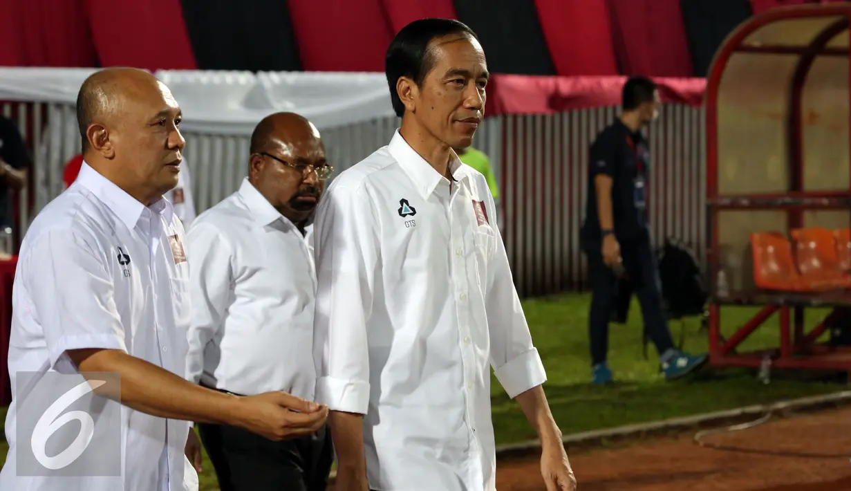 Presiden RI, Joko Widodo (depan) bersiap meniup peluit dimulainya babak kedua laga Persipura vs Persija di Torabika Soccer Championship presented by IM3 Ooredoo di Stadion Mandala Jayapura,Papua, Jumat (29/4/2016). (Liputan6.com/Helmi Fithriansyah)