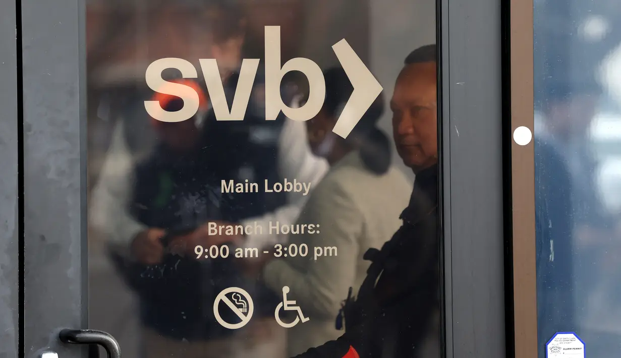 Seorang penjaga keamanan memantau barisan orang yang mencoba mengambil kembali dana mereka di luar kantor Silicon Valley Bank di Santa Clara, California, Senin (13/3/2023). Silicon Valley Bank (SVB) tengah menjadi sorotan karena mengalami kebangkrutan bank terbesar di Amerika Serikat sejak tahun 2008. ( Justin Sullivan/Getty Images/AFP )