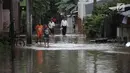 Warga beraktivitas saat banjir merendam kawasan Cipinang Melayu, Jakarta Timur, Senin (5/2). Akibat intensitas hujan yang cukup tinggi, permukiman di wilayah Cipinang Melayu tergenang air setinggi 30-40 cm. (Liputan6.com/Arya Manggala)